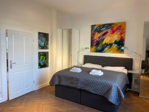 a bedroom with a bed and a painting on the wall at Apartment Factory in Hamburg