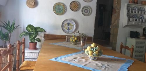a dining room with a table and plates on the wall at La cascina della grotta di tufo in San Valentino
