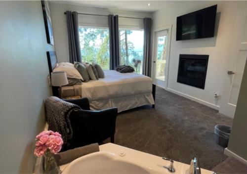 a bedroom with a bed with a fireplace and a sink at Quarrystone House B&B in Fernwood