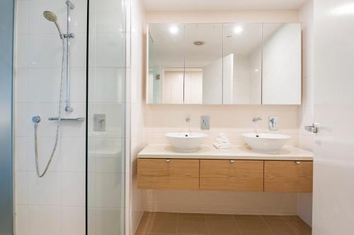 a bathroom with two sinks and a shower at Darwin Waterfront Luxury Suites in Darwin