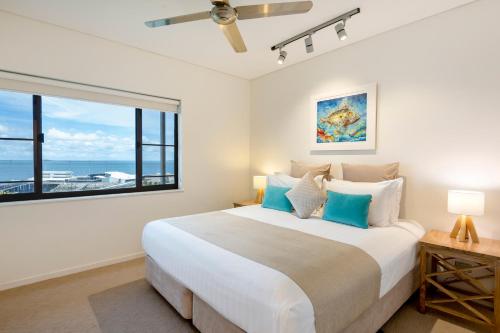 a bedroom with a large bed and a large window at Darwin Waterfront Luxury Suites in Darwin