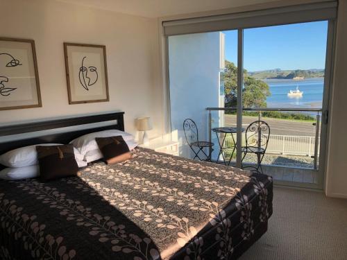 a bedroom with a bed and a large window at Ohope Beach Resort in Ohope Beach
