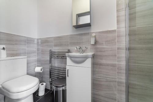 a bathroom with a toilet and a sink at Highlands Gardens Suites in Ilford