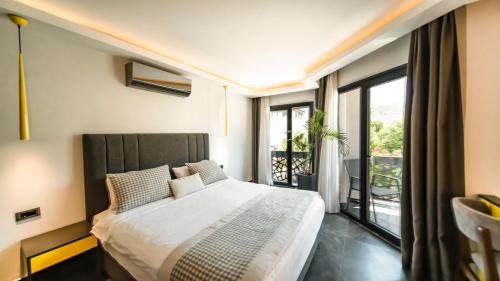 a bedroom with a large bed and a balcony at Sea Palm Otel Yalıkavak in Yalıkavak