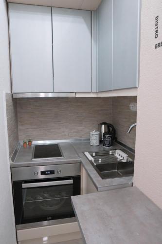 a kitchen with white cabinets and a stove top oven at NOA Luxury Apartment in Bitola