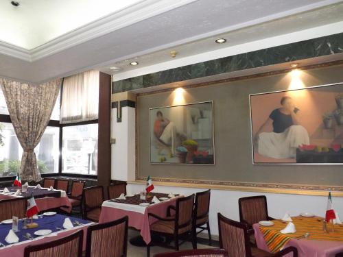 a restaurant with tables and chairs and paintings on the wall at Pedregal Palace in Mexico City