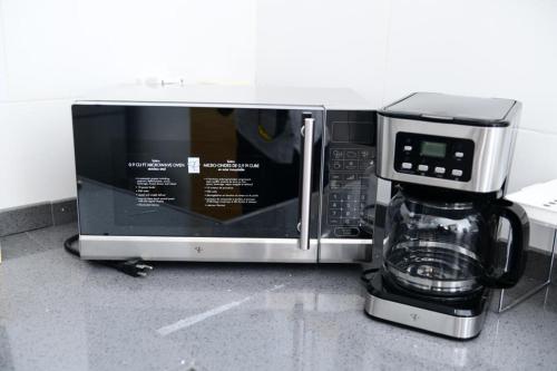 a microwave sitting on a counter with a coffee maker at Appartement F4 vue panoramique sur Dakar in Dakar