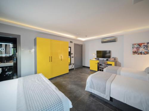 a bedroom with two beds and a yellow cabinet at Sea Palm Otel Yalıkavak in Yalıkavak