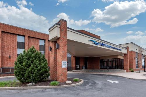 a large brick building with a tree in front of it at Best Western Plus Oswego Hotel and Conference Center in Oswego