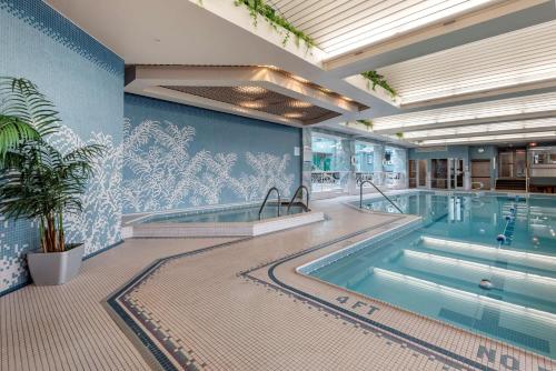 a large swimming pool in a building with a mural at Best Western Plus Oswego Hotel and Conference Center in Oswego