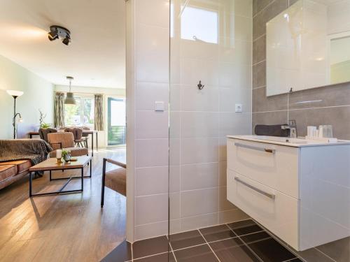 eine Küche mit einem Waschbecken und ein Wohnzimmer in der Unterkunft Tiny Zwarte Mees in Hulshorst