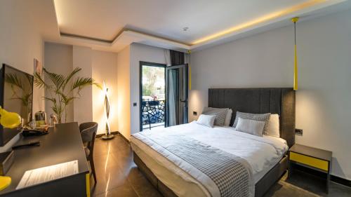 1 dormitorio con 1 cama grande, escritorio y en Sea Palm Otel Yalıkavak, en Yalıkavak