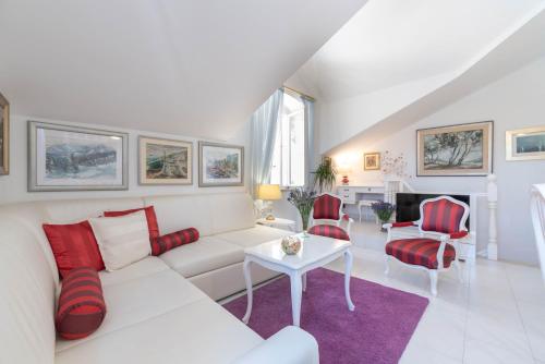 a living room with a white couch and red chairs at Apartment Rosana - ZF Hvar in Hvar