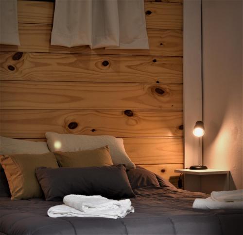 sypialnia z drewnianym zagłówkiem i łóżkiem w obiekcie Las Casitas 1 w mieście San Martín de los Andes