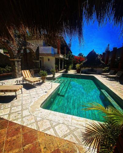 a swimming pool with two chairs next to a house at Casa Miura Hotel Boutique in Ajijic