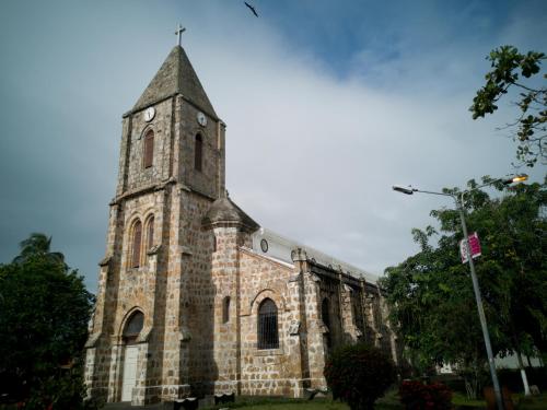 a church with a tower with a clock on it at Hotel Aldea Pura Vida in Puntarenas