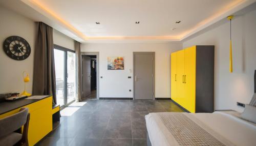 a bedroom with a bed and a yellow cabinet at Sea Palm Otel Yalıkavak in Yalıkavak