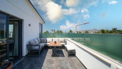 a patio with a table and chairs on a balcony at Sea Palm Otel Yalıkavak in Yalıkavak