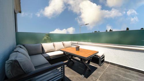 a couch and a table on a balcony at Sea Palm Otel Yalıkavak in Yalıkavak