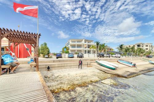 a flag flying over a beach with boats on the sand at Seaside Governor Suite in Kralendijk