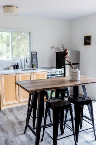 a kitchen with a wooden table and black stools at Muskoka Waterfront Retreat in Dwight