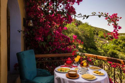 a table with plates of food on a balcony with flowers at Dar Echchaouen Maison d'Hôtes & Riad in Chefchaouene
