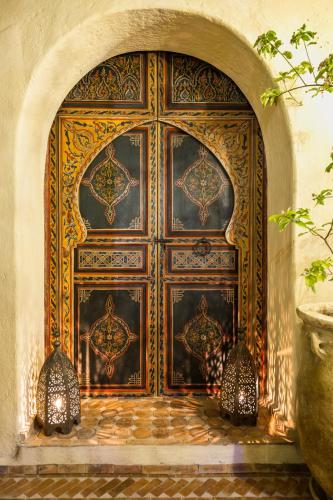 an ornate wooden door in a room with a stone floor at Dar Echchaouen Maison d'Hôtes & Riad in Chefchaouene