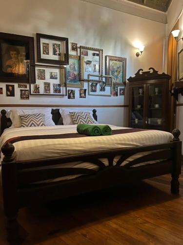a bedroom with a large bed with pictures on the wall at 103 - Bed and Brews in Bangkok