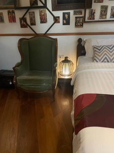 a bedroom with a bed and a green chair at 103 - Bed and Brews in Bangkok