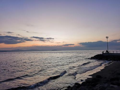 a sunset over the ocean with a pier and the water at Hotel Aldea Pura Vida in Puntarenas