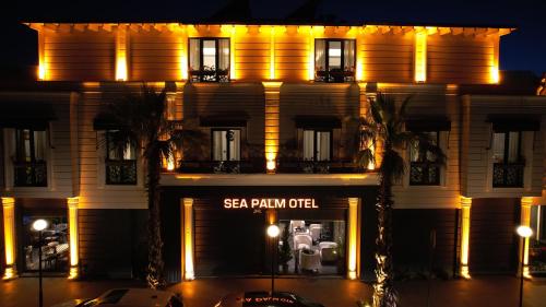 a building with a sign in front of it at night at Sea Palm Otel Yalıkavak in Yalıkavak