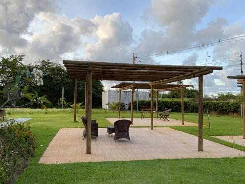 einem Pavillon mit Stühlen und einem Tisch in einem Park in der Unterkunft Flat Garden 113 Muro Alto Condominio Clube in Porto De Galinhas