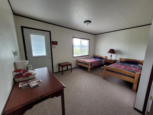 um quarto com duas camas e uma mesa em Eagles Landing Campground em Sturgis