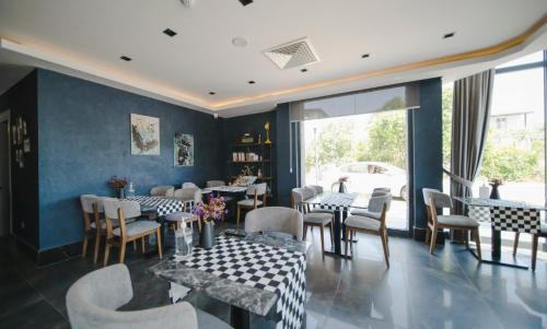a restaurant with tables and chairs and a large window at Sea Palm Otel Yalıkavak in Yalıkavak