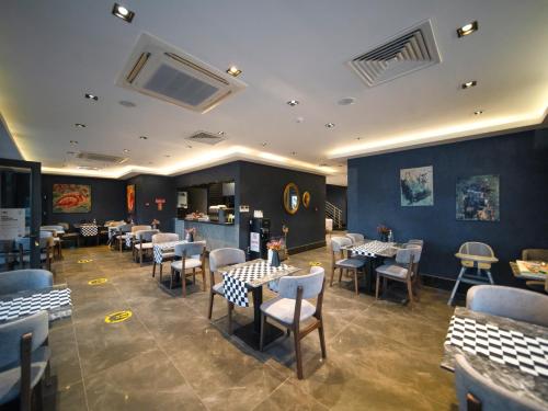 a restaurant with tables and chairs in a room at Sea Palm Otel Yalıkavak in Yalıkavak