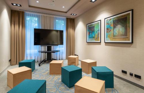 a room with boxes and a flat screen tv at Leonardo Hotel Augsburg in Augsburg