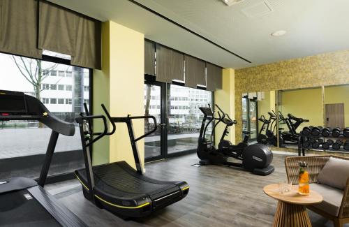 a gym with treadmills and elliptical machines at Leonardo Hotel Offenbach Frankfurt in Offenbach