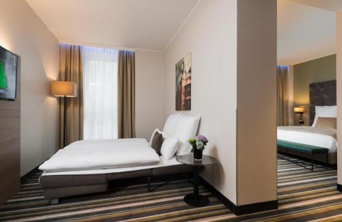 a hotel room with a bed and a window at Leonardo Hotel Offenbach Frankfurt in Offenbach
