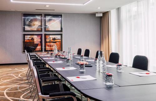 a large conference room with a long table and chairs at Leonardo Hotel Zurich Airport in Kloten