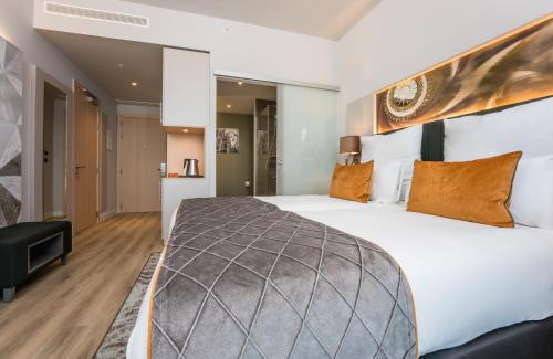 a bedroom with a large bed in a room at Leonardo Royal Hotel Barcelona Fira in Barcelona