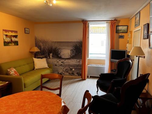 un salon avec un canapé et une table dans l'établissement Studio cosy pour 2 à 50m de la plage, centre-ville, tout équipé - FR-1-197-507, à Les Sables-dʼOlonne