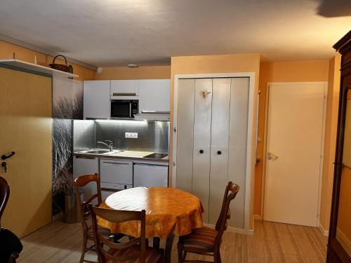 une petite cuisine avec une table dans une pièce dans l'établissement Studio cosy pour 2 à 50m de la plage, centre-ville, tout équipé - FR-1-197-507, à Les Sables-dʼOlonne