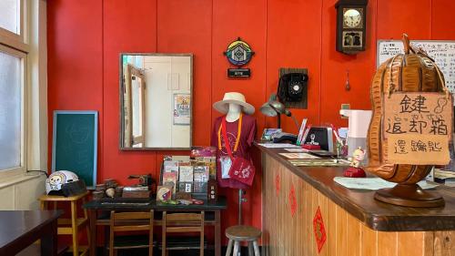 ein Restaurant mit roten Wänden und einer Theke mit einem Spiegel in der Unterkunft Tainan Guest House Hamuya in Tainan