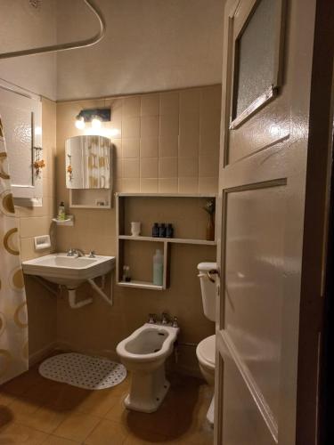 a small bathroom with a toilet and a sink at Casa confortable - Parque central - Estacionamiento, patio, 3 baños, 5 habitaciones - in La Cieneguita