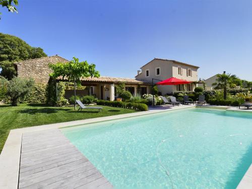 une piscine devant une maison dans l'établissement Charmante Villa à Eygalière avec Piscine, Jardin Arboré et Climatisation - FR-1-599-19, à Eygalières