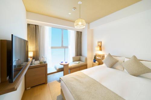 Hotel Resol Trinity Naha في ناها: غرفة نوم بسرير كبير وتلفزيون