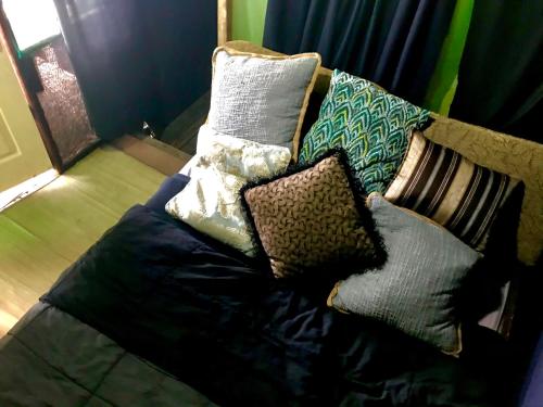 a couch with pillows on it in a room at Beachfront Paradise in Manuel Antonio