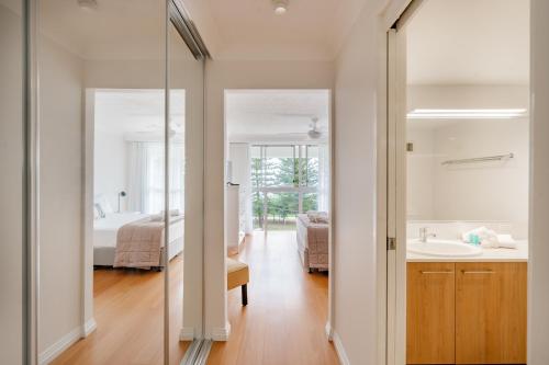 a bathroom with a tub and a sink and a mirror at Cashelmara Beachfront Apartments in Gold Coast