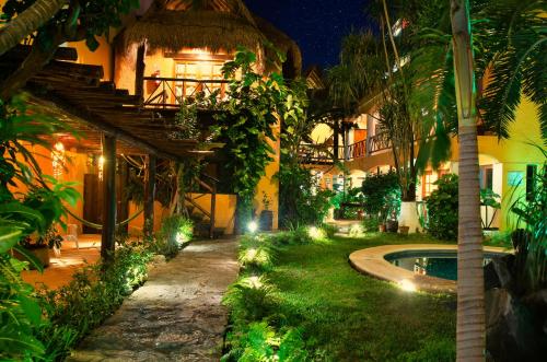a courtyard of a house with a swimming pool at night at Hotel Bosque Caribe, 5th Av. zone in Playa del Carmen