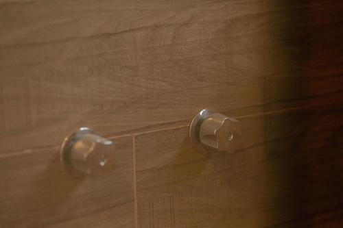 a wooden door with two handles on a wooden floor at Hotel Fratelli in Aguascalientes